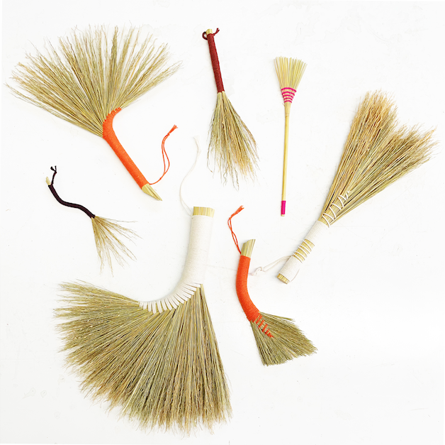 a bunch of hand made hand brooms