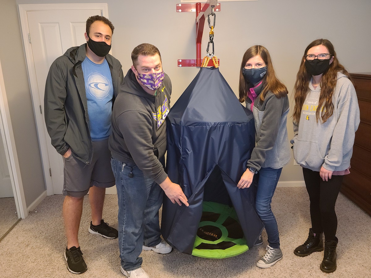 Mechanical engineering students Emily Carroll, Gabriel DaSilva, Lexie Carrier and John Wagner with custom designed sensory swing they designed and built