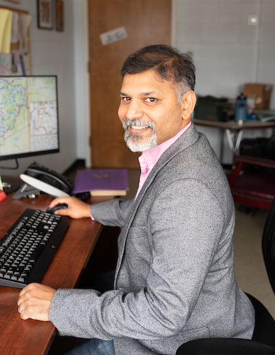 Alfred Kalyanapu, Ph.D. sitting at office desk