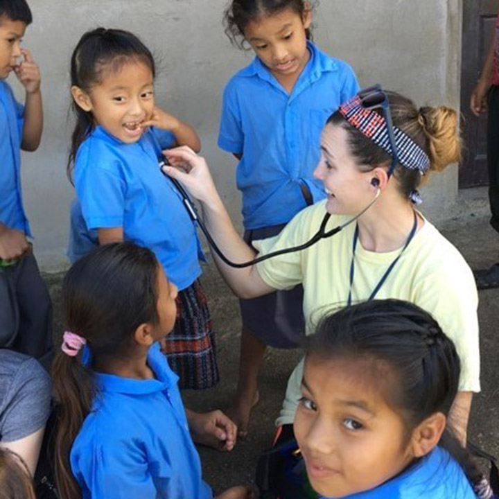 A student on a service trip overseas helping children. 