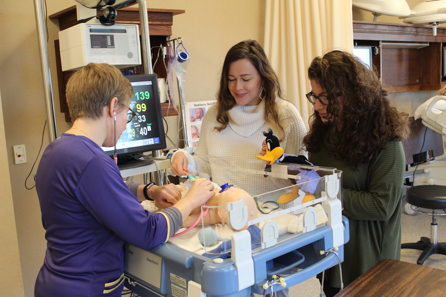 Former child life students Lila Easter, Sarah Dowd and Kari Lockmiller work in the simulation lab.