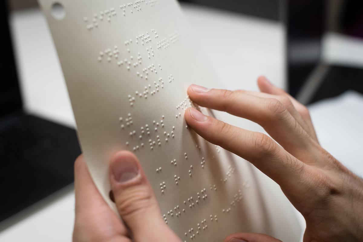 Computer science instructor April Crockett helps students Vadim Kholodilo and Carlos Medrano with tactile diagrams printed in braille.