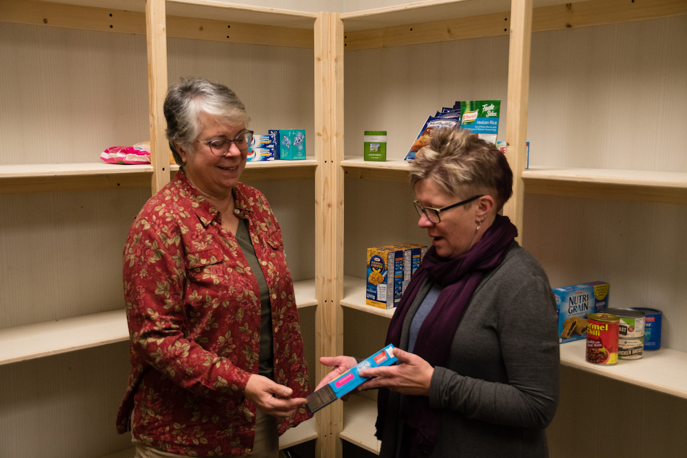 Rose Black, left, with the Volpe Library, looks over some of the items in the auxiliary food pantry with Ann Manginelli, a public service librarian.