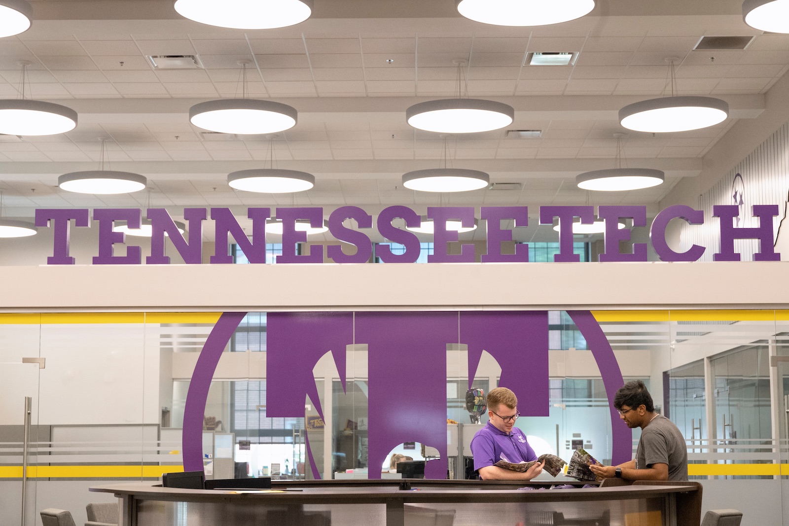 Tech student Pranav Patel (right) visits with admissions staff in the Jere Whitson Building on Tech's campus