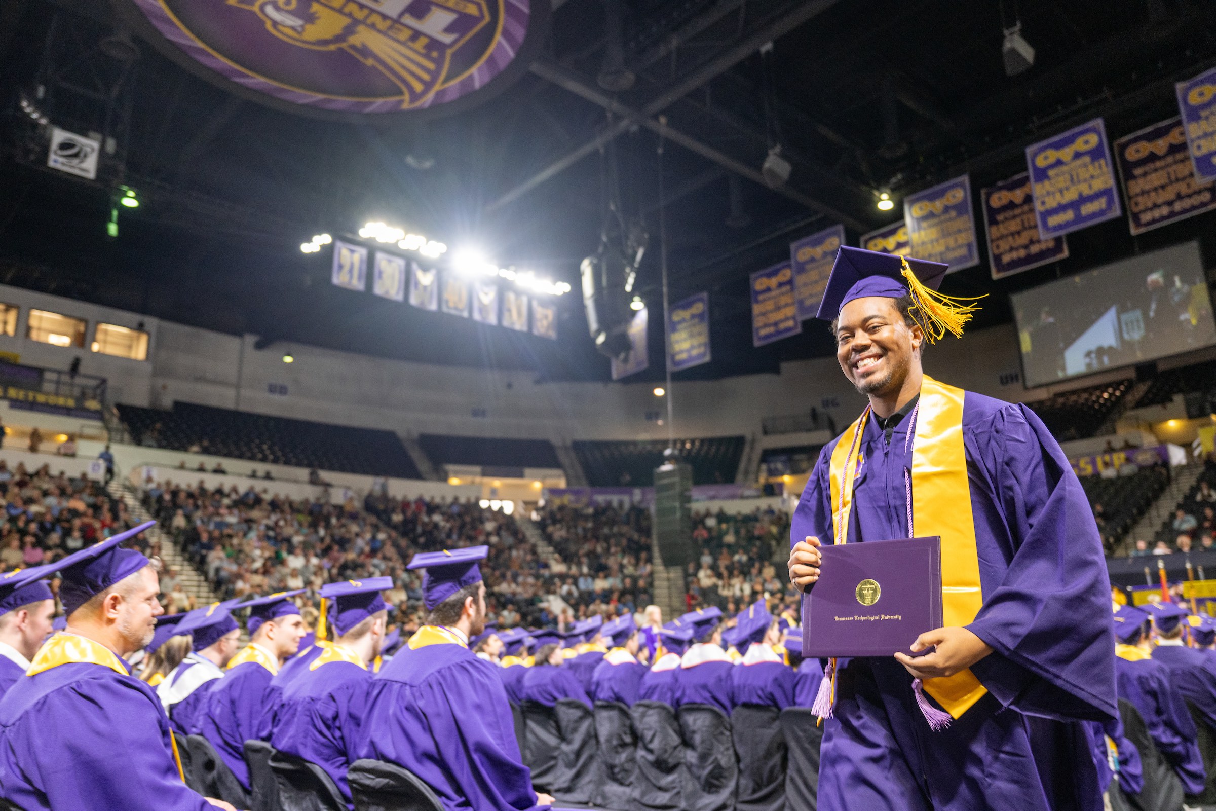 A new Tennessee Tech graduates poses with his degree.