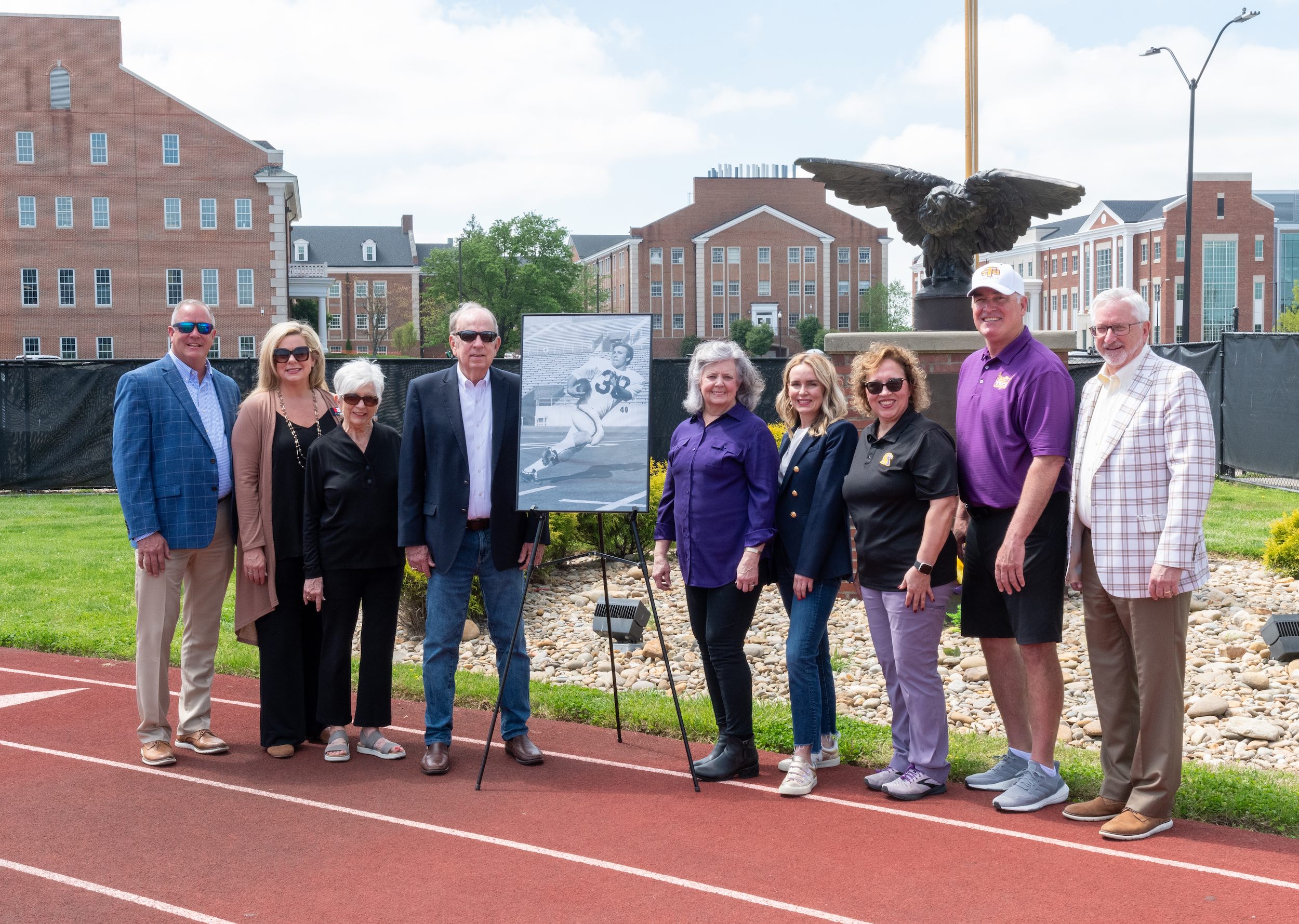 Members of the Gaw and Phillips families are pictured with Tennessee Tech leaders and a portrait of the late Ottis Phillips. From left: Tech Athletics Director Mark Wilson, Jill Gaw Betcher, Brenda Gaw, Jerry C. Gaw, Cindy Phillips, Emily Phillips Rains, Kristie Phillips, Tech Head Football Coach Bobby Wilder and Tech President Phil Oldham. 