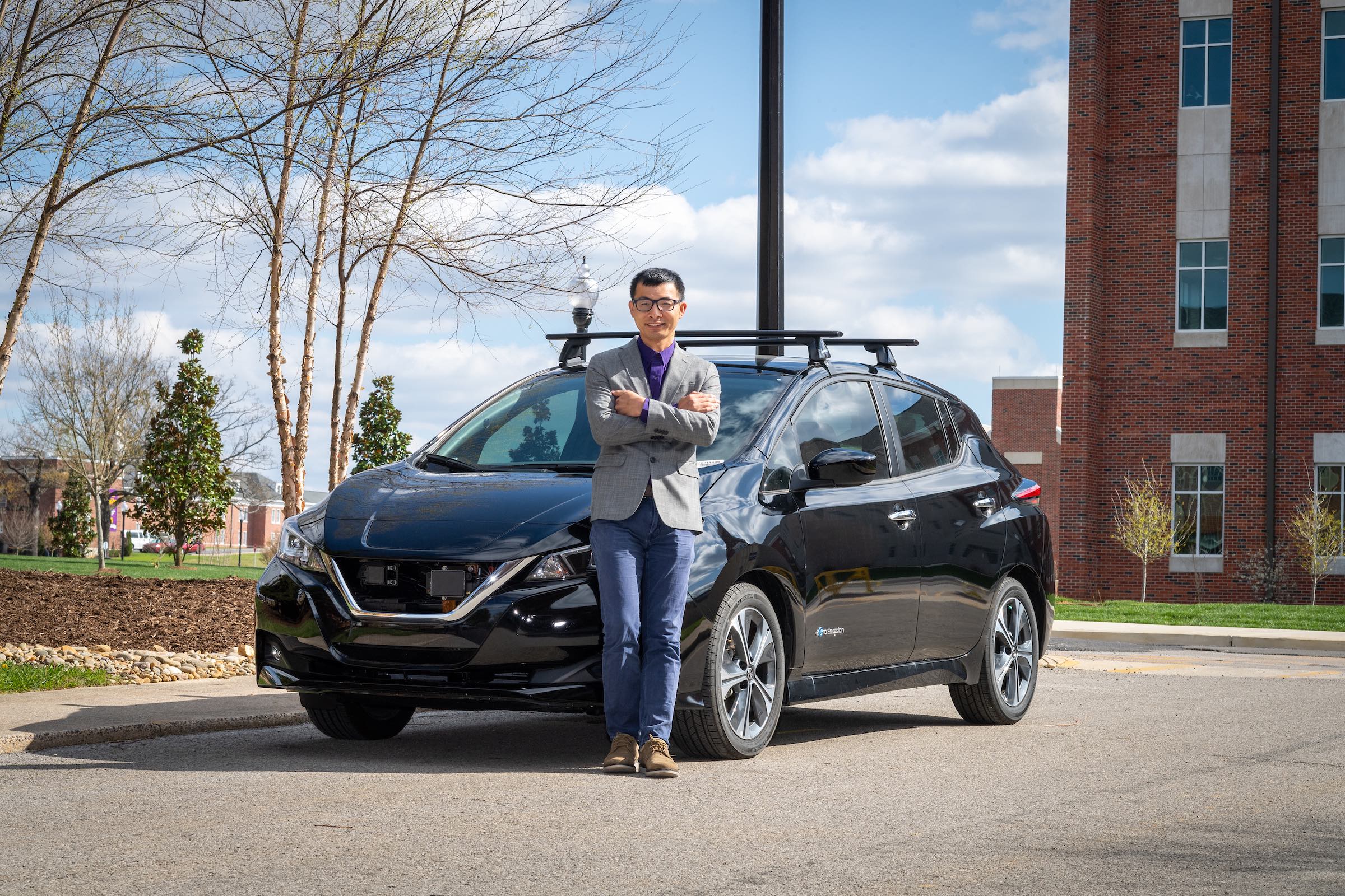 Dr. Pingen Chen is pictured standing in front of a 2019 Nissan Leaf, part of a fleet of electric vehicles used in Tennessee Tech's research and outreach efforts. 