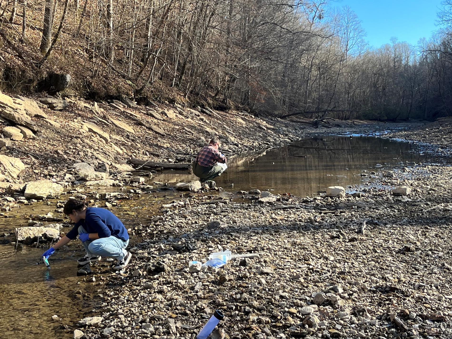 Gabi De Almeida, a master's student in civil and environmental engineering, and Peter Blum, a Ph.D. student in environmental sciences and biology, collect samples for per- and polyfluoroalkyl substances (PFAS) in a central Tennessee stream.