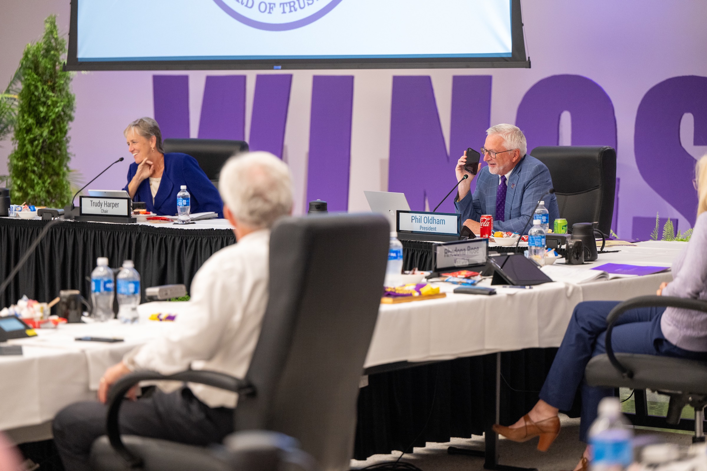 Tech President Phil Oldham takes a surprise phone call fro Barry Wilmore while Board Chair Trudy Harper looks on.