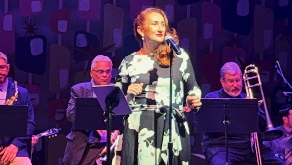 Melissa Ellis Mellisa Ellis is seen performing on a stage with musicians in the background